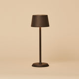 Lampe de table sans fil rechargeable Tavellio Brouwer Mini Mocha en métal texturé, vue de face sur fond neutre, allumée.