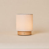 Dick brun clair, lampe de table rechargeable Tavellio en lin beige sur base en bois clair, photo studio