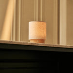 Dick brun clair, lampe de table sans fil Tavellio en lin sur base en bois clair, posée sur tablette en marbre au soleil