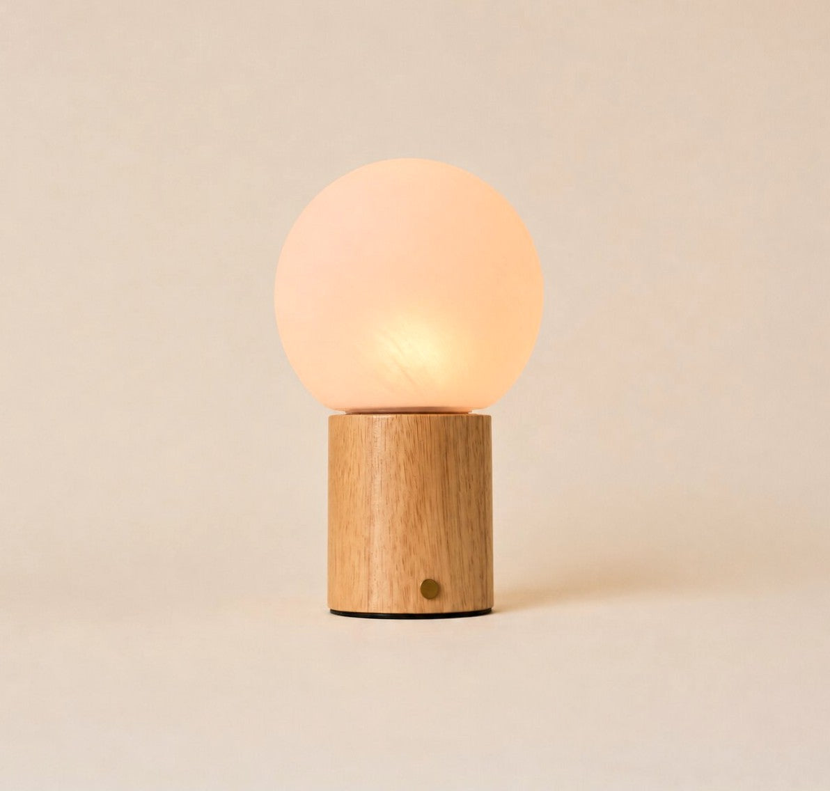 Flore oplaadbare tafellamp met lichtbruin houten voet en glazen bol op lichte achtergrond
