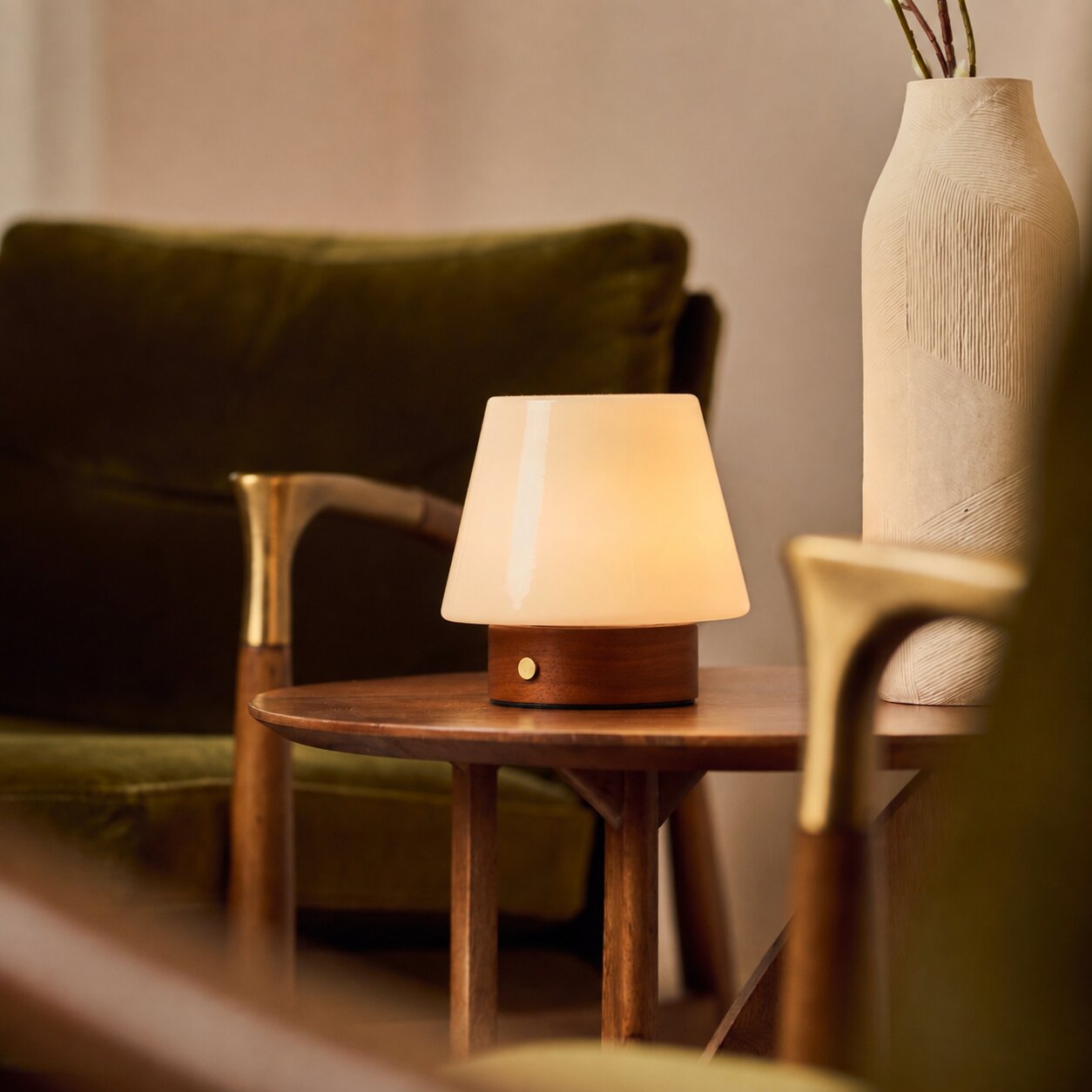 Oplaadbare tafellamp Jadey Small kastanjebruin hout op houten bijzettafel naast groene bank
