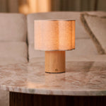 Lucy bois clair lampe de table rechargeable Tavellio – abat-jour tambour en lin – sur une table basse en marbre