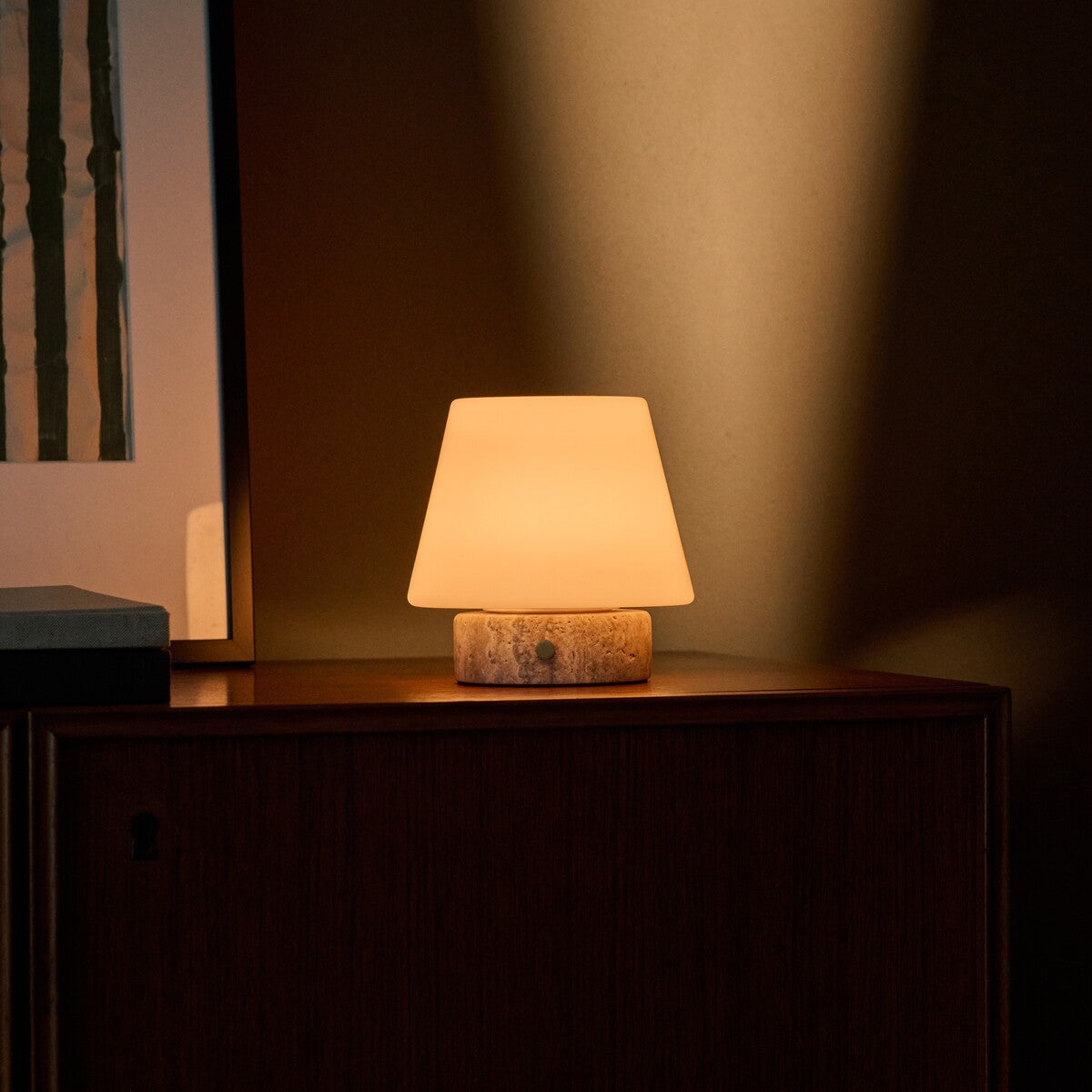 Hooch oplaadbare tafellamp met travertin voet, warm licht naast ingelijst kunstwerk op dressoir