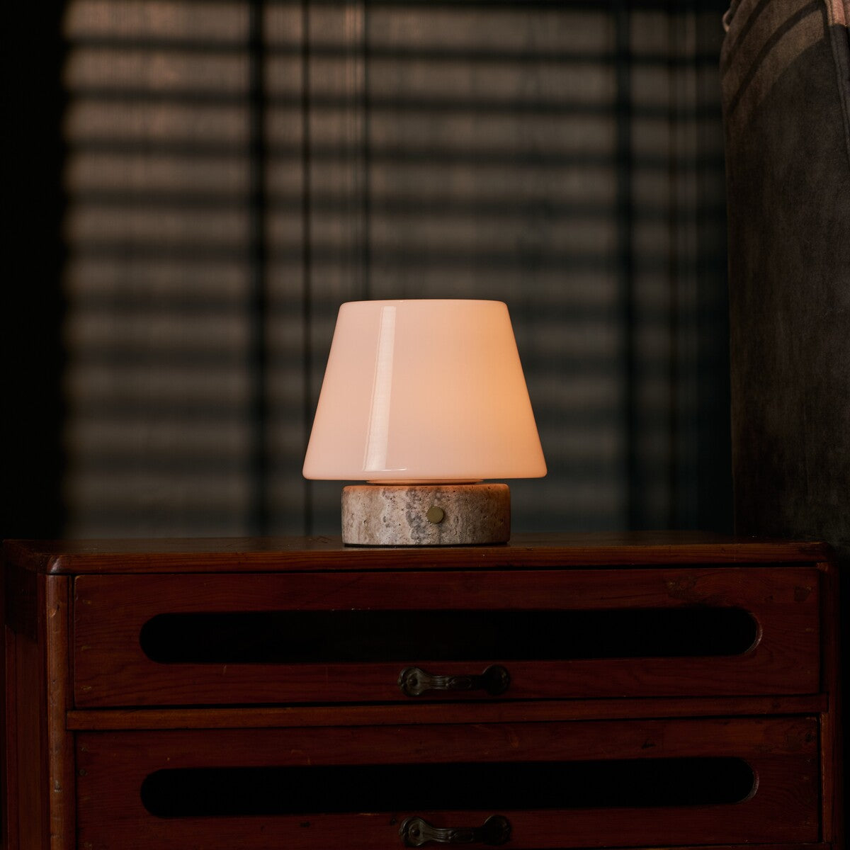 Hooch oplaadbare tafellamp met zilverkleurige travertin voet op een donker houten dressoir