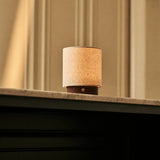 Oplaadbare tafellamp Dick Small Dark Brown, linnen kap op donker houten voet, op marmeren schouwrand