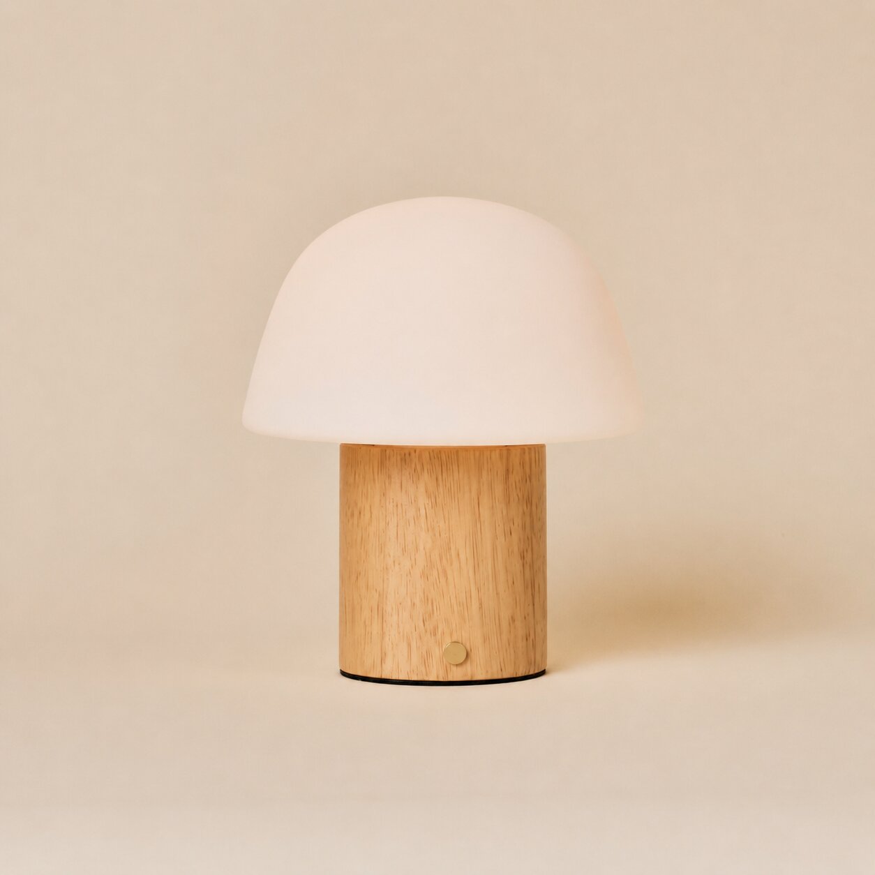 Cordless table lamp Ton with light brown wood base and frosted glass dome shade on a neutral background