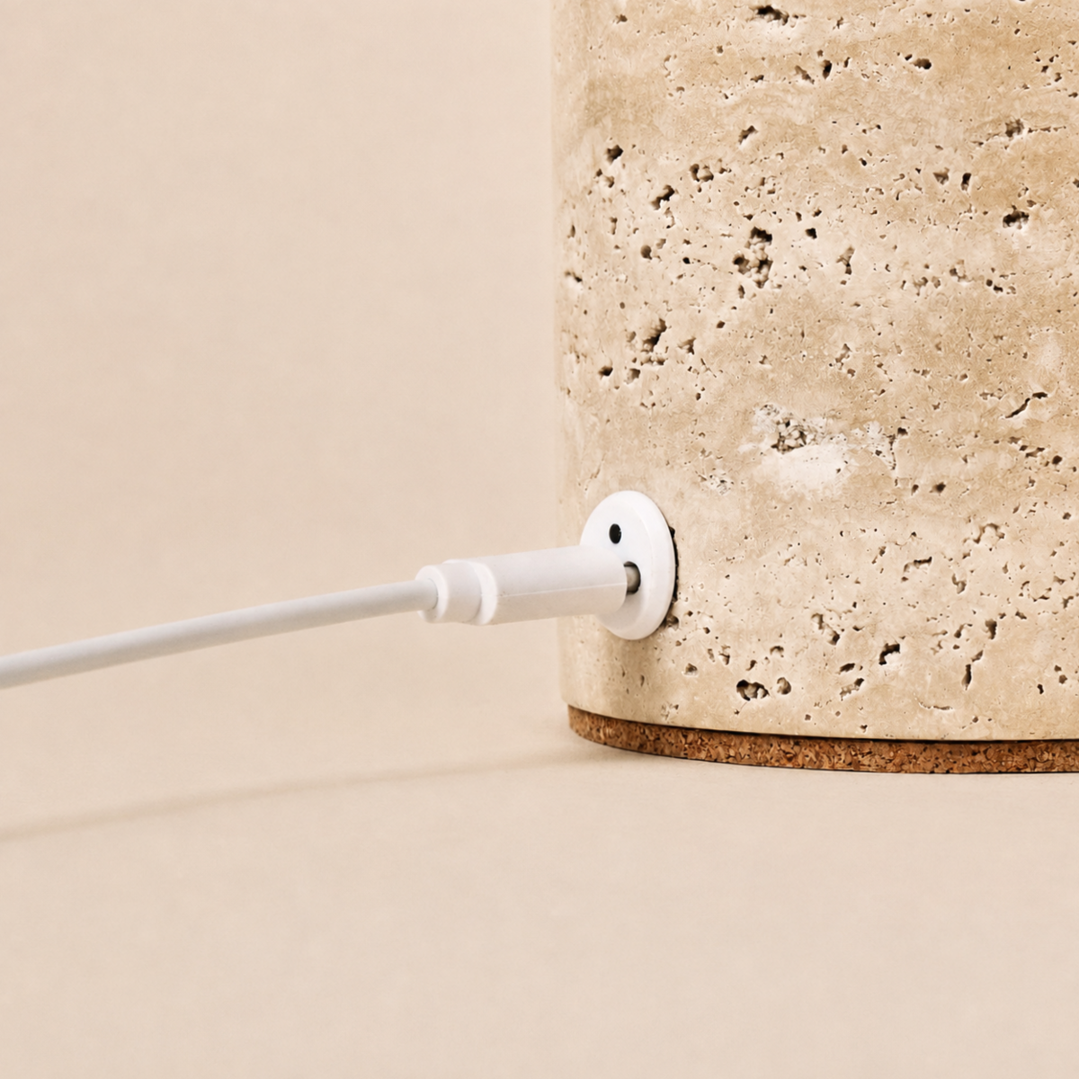 Close-up of the USB charging cable plugged into the Keyser travertine lamp base