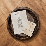 Tavellio user guide and Amsterdam-designed card resting on a dark marble tray