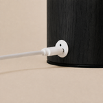Magnetic charging cable connecting to the black wooden base of the Luna rechargeable table lamp