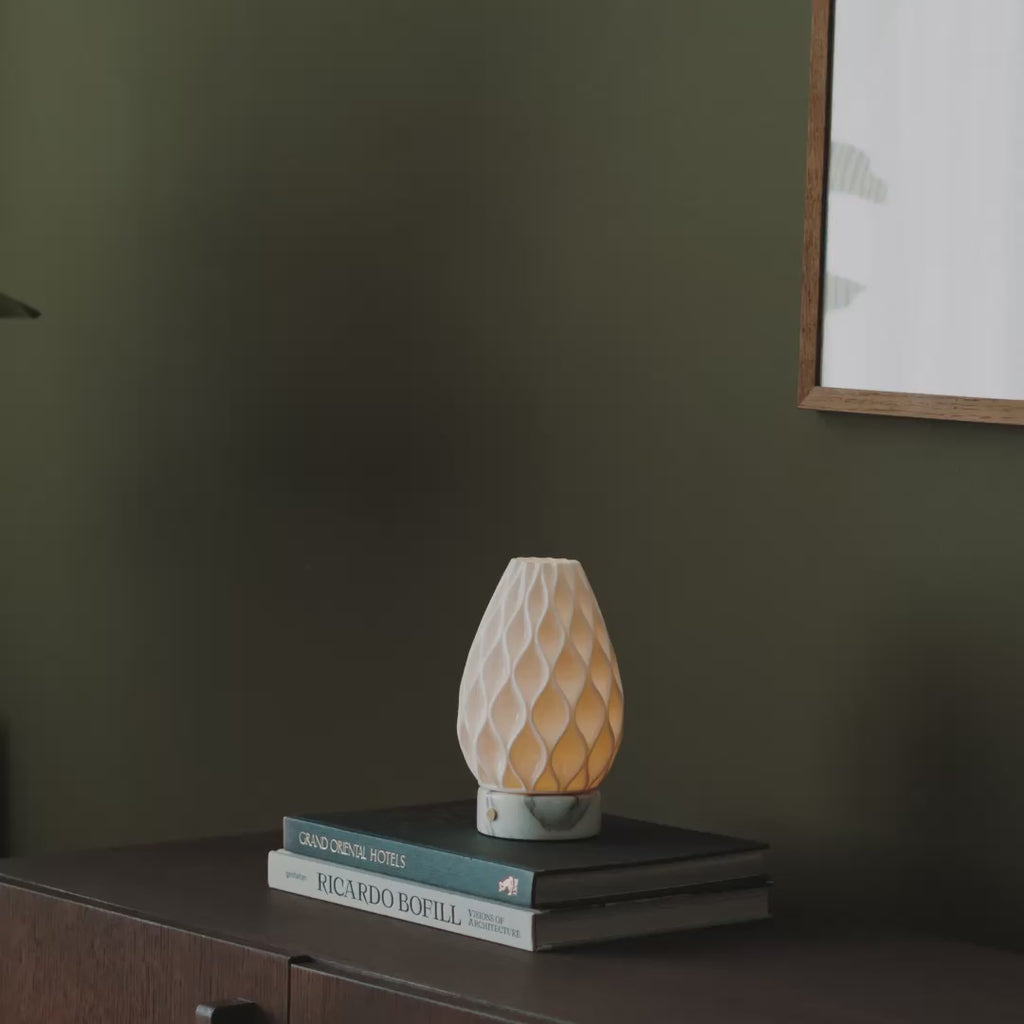 Short video of Tavellio rechargeable table lamps with 3D-printed porcelain shades, lit in a cosy living room